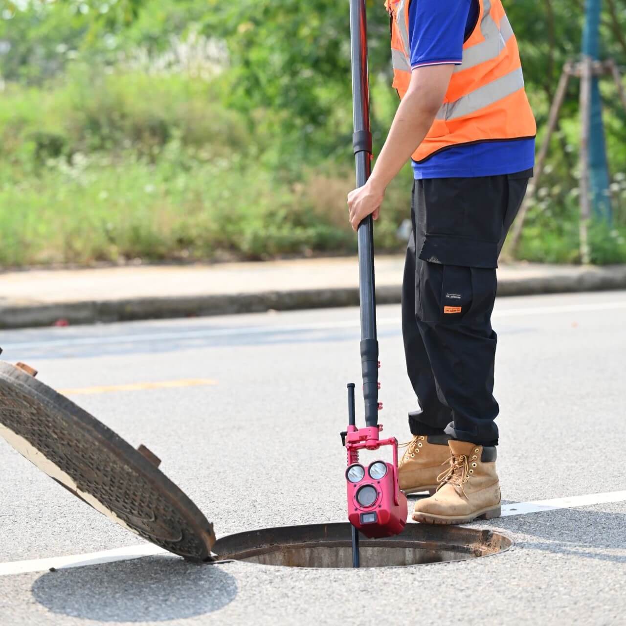 Mainline Zoom Inspection Camera being lowered down into a manhole